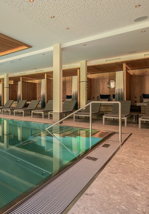 Modernes Hallenbad mit Bergblick und Liegen