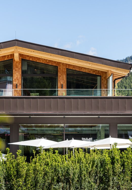 Modernes Hotelgebäude mit Holzfassade und Bergblick