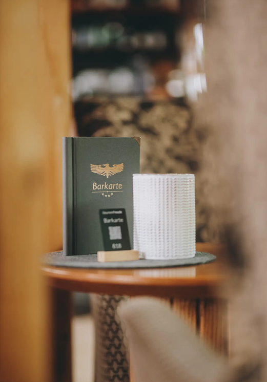 Barkarte, Zimmerkarte und Papierstapel auf Tisch im Hotel Tyrol