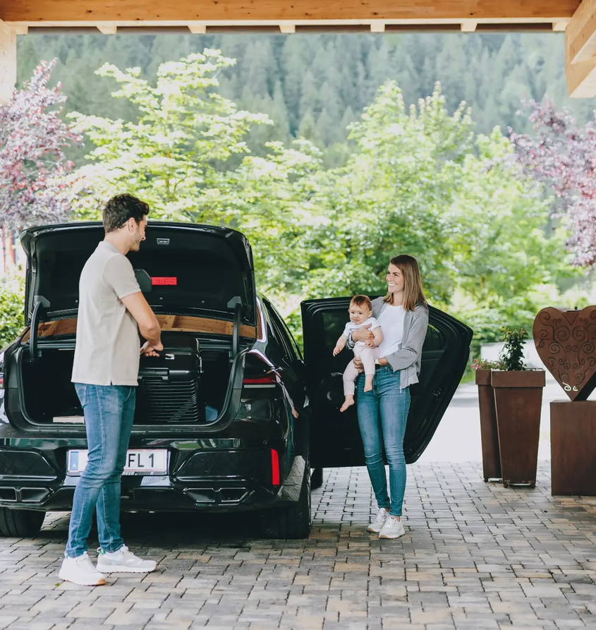 Familie packt Gepäck am Hotel Tyrol aus
