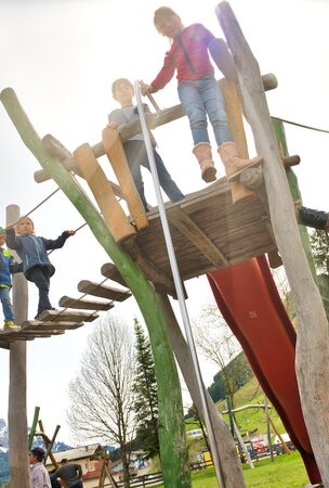 Kinder spielen auf Holzspielplatz