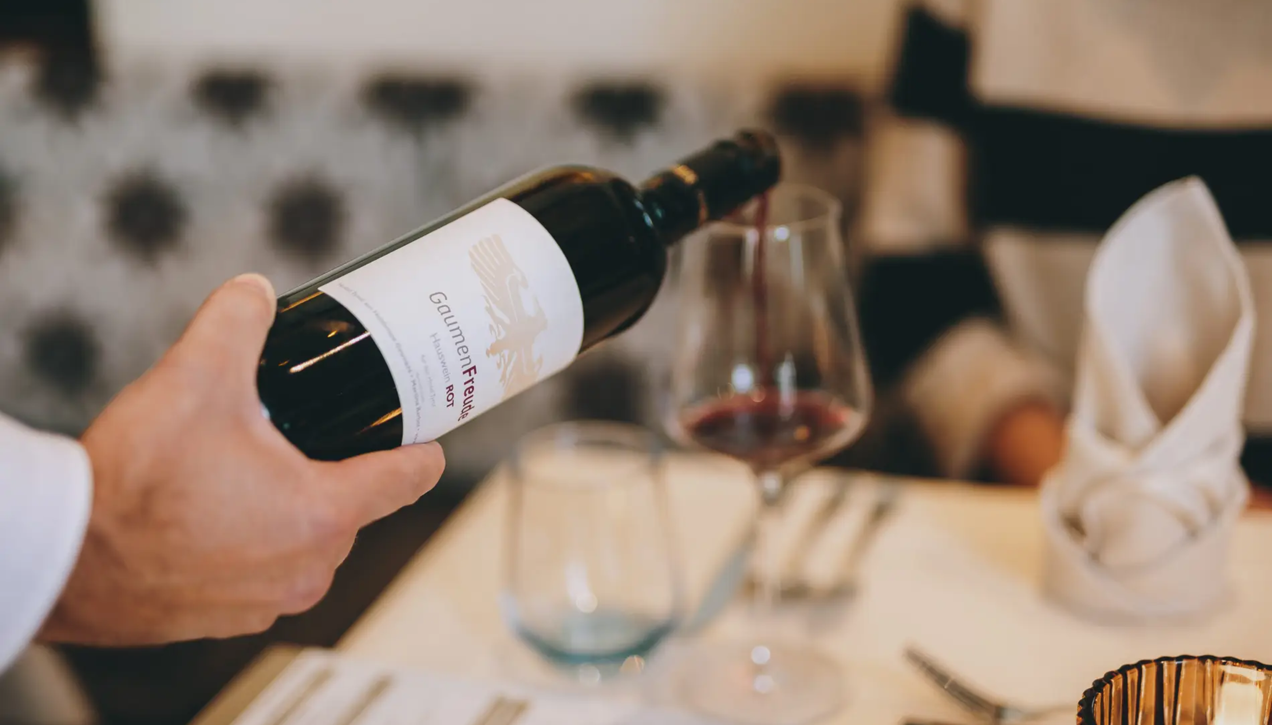 Red wine is poured into the glass