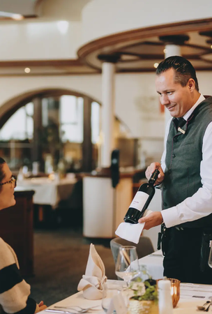 Hotel Tyrol Haldensee: Kellner serviert Wein im Restaurant