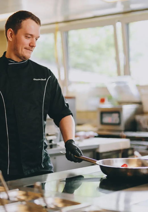 Koch brät in Pfanne in Hotel Tyrol Küche