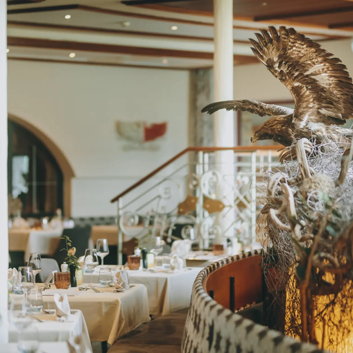 Hotel Tyrol: Restaurant mit Adler-Skulptur und gedeckten Tischen