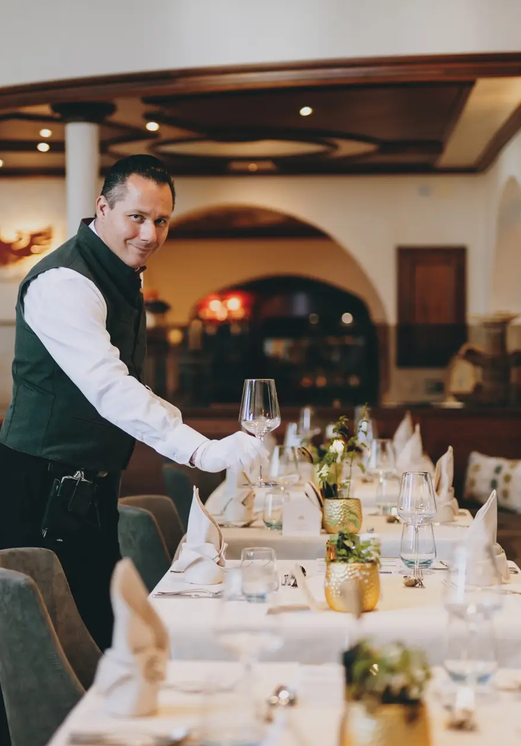 Kellner deckt Tisch im Hotel Tyrol am Haldensee