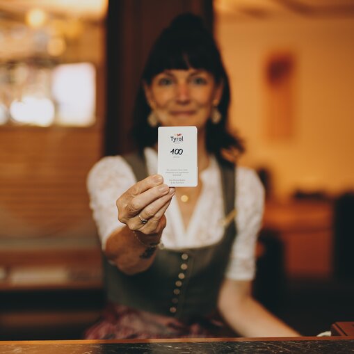 Hotel Tyrol Mitarbeiterin zeigt Zimmerschlüssel Zimmer 100
