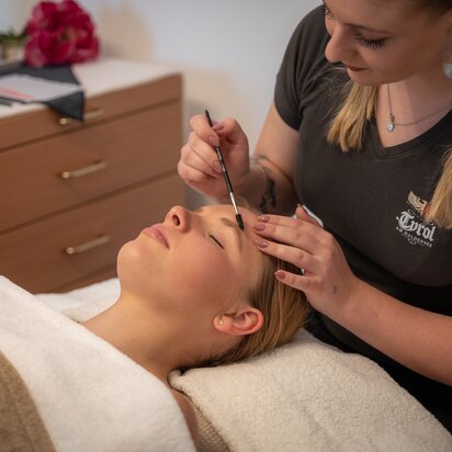 Frau erhält Augenbrauenbehandlung im Hotel Tyrol