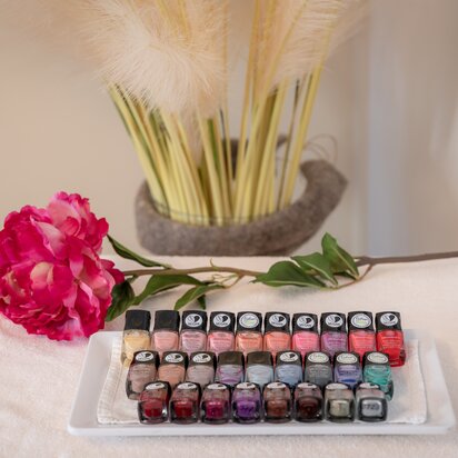 Nagellacke auf Tablett mit Blume