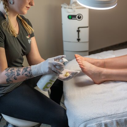 Wellnessanwendung: Frau behandelt Füße im Hotel Tyrol