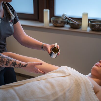 Wellnessanwendung im Hotel Tyrol: Frau erhält Ölmassage