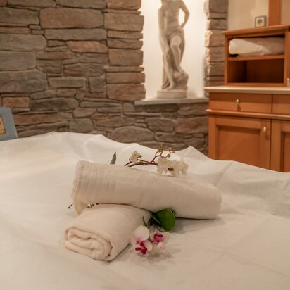 Wellnessbereich: Handtücher und Orchideen auf Massageliege