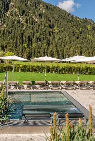 Whirlpool im Hotel Tyrol am Haldensee mit Liegen und Sonnenschirmen