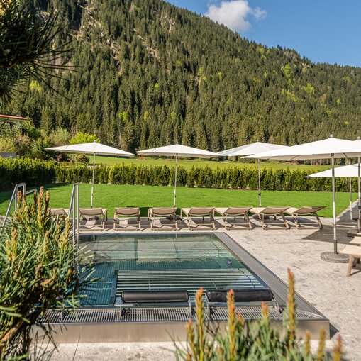 Whirlpool im Hotel Tyrol am Haldensee mit Liegen und Sonnenschirmen