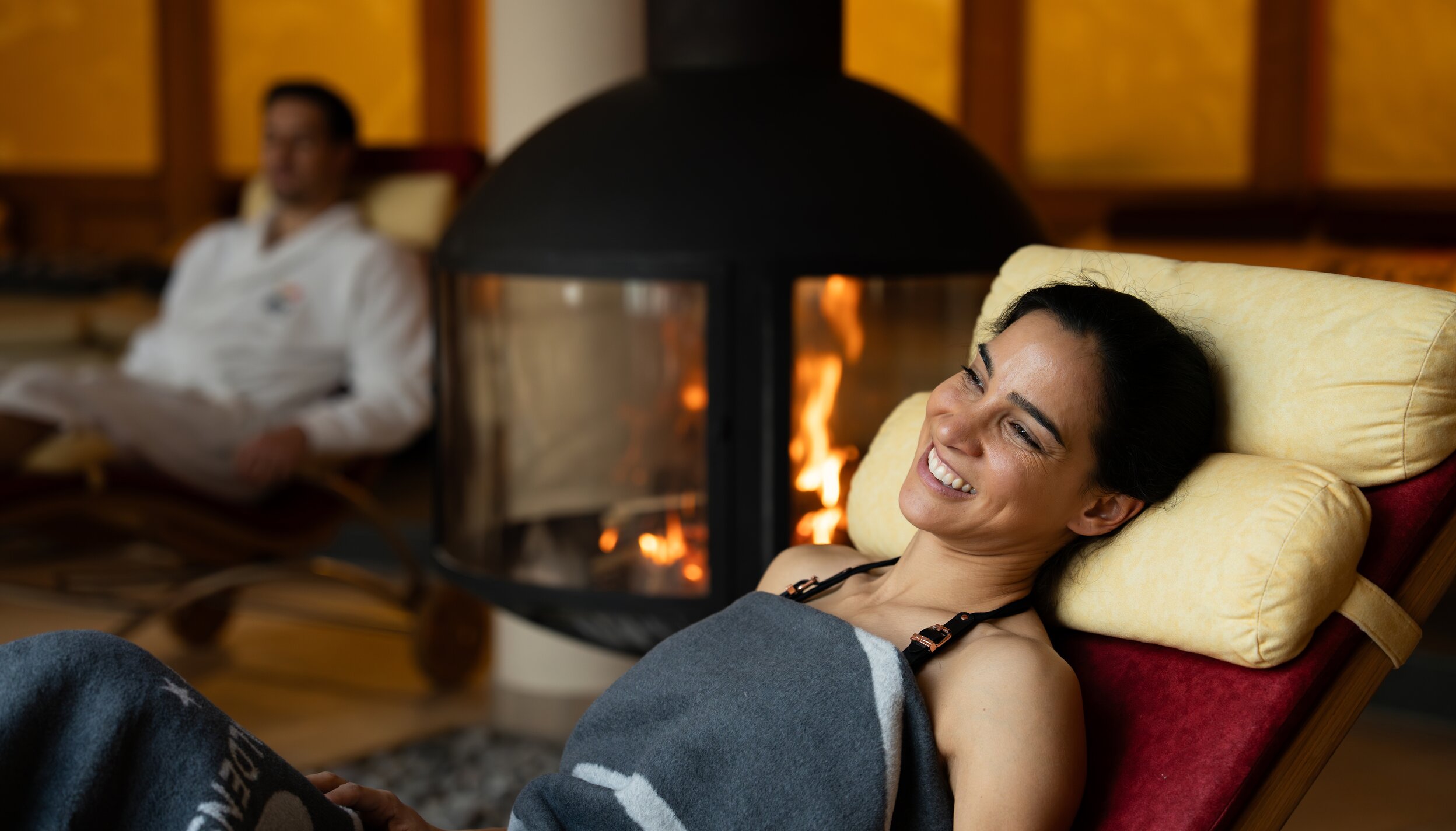 Frau entspannt vor Kamin im Hotel Tyrol am Haldensee