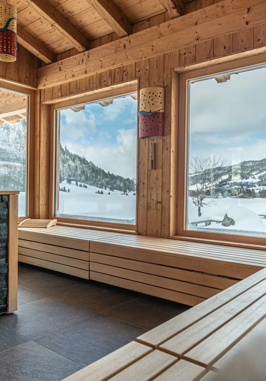 Holzsauna mit Blick auf verschneite Berge im Hotel Tyrol am Haldensee