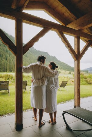 Paar in Bademänteln mit Blick auf die Berge