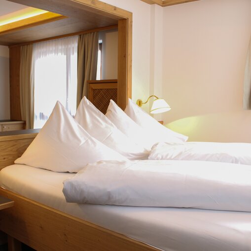 Hotel Tyrol Haldensee: Zimmer mit Bett und weißen Kissen