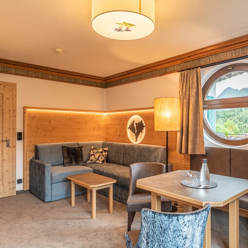 Hotel Tyrol Zimmer mit Sitzecke und rundem Fenster