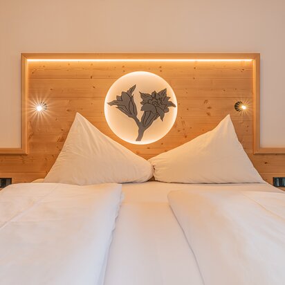 Bett in Enziansuite im Hotel Tyrol am Haldensee