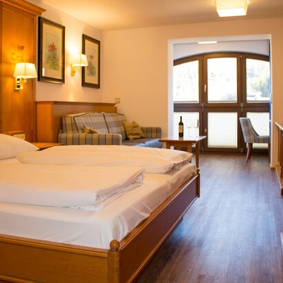 Hotel Tyrol: Wohn-Schlafbereich mit Bett, Sofa und Balkon