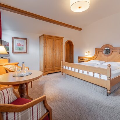 Hotel Tyrol Zimmer mit Doppelbett und Holzmöbeln