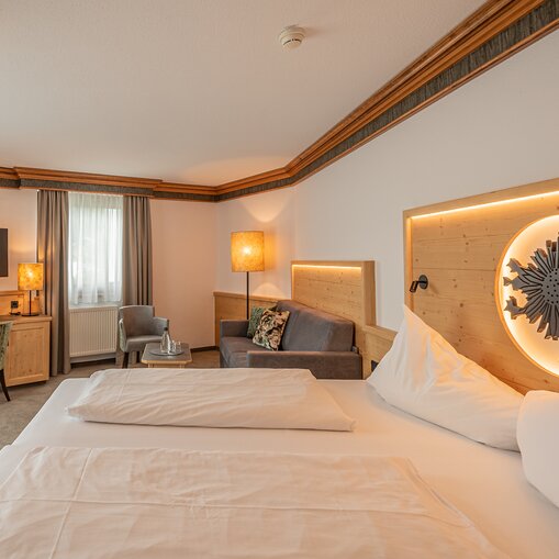 Hotel Tyrol: Zimmer mit Bett, Sofa und Lampe