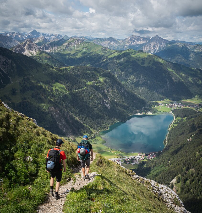 Wanderer blicken auf Haldensee und Berglandschaft