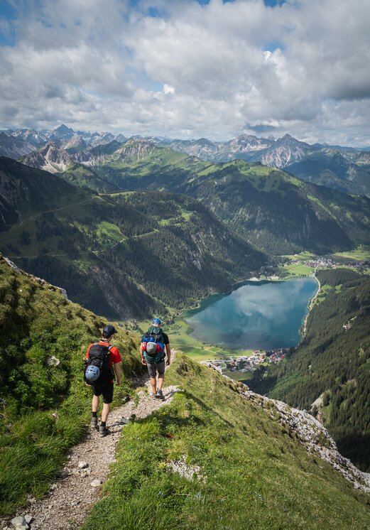 Wanderer blicken auf Haldensee und Berglandschaft