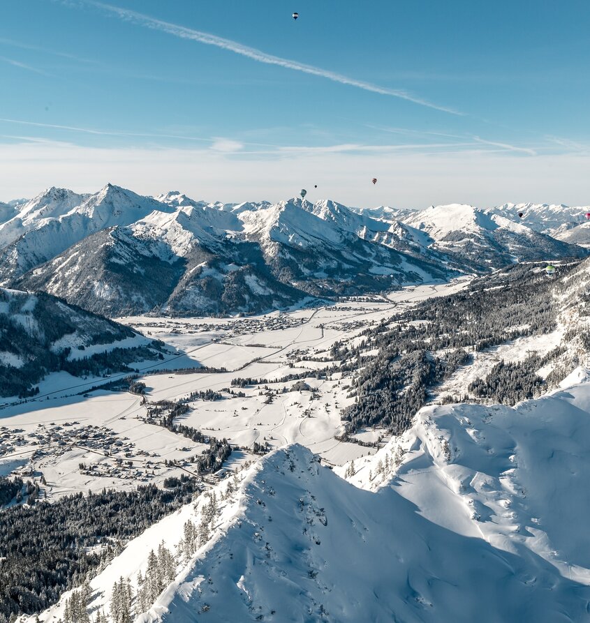 Winterliche Berglandschaft mit Ballonfestival am Haldensee in Tirol
